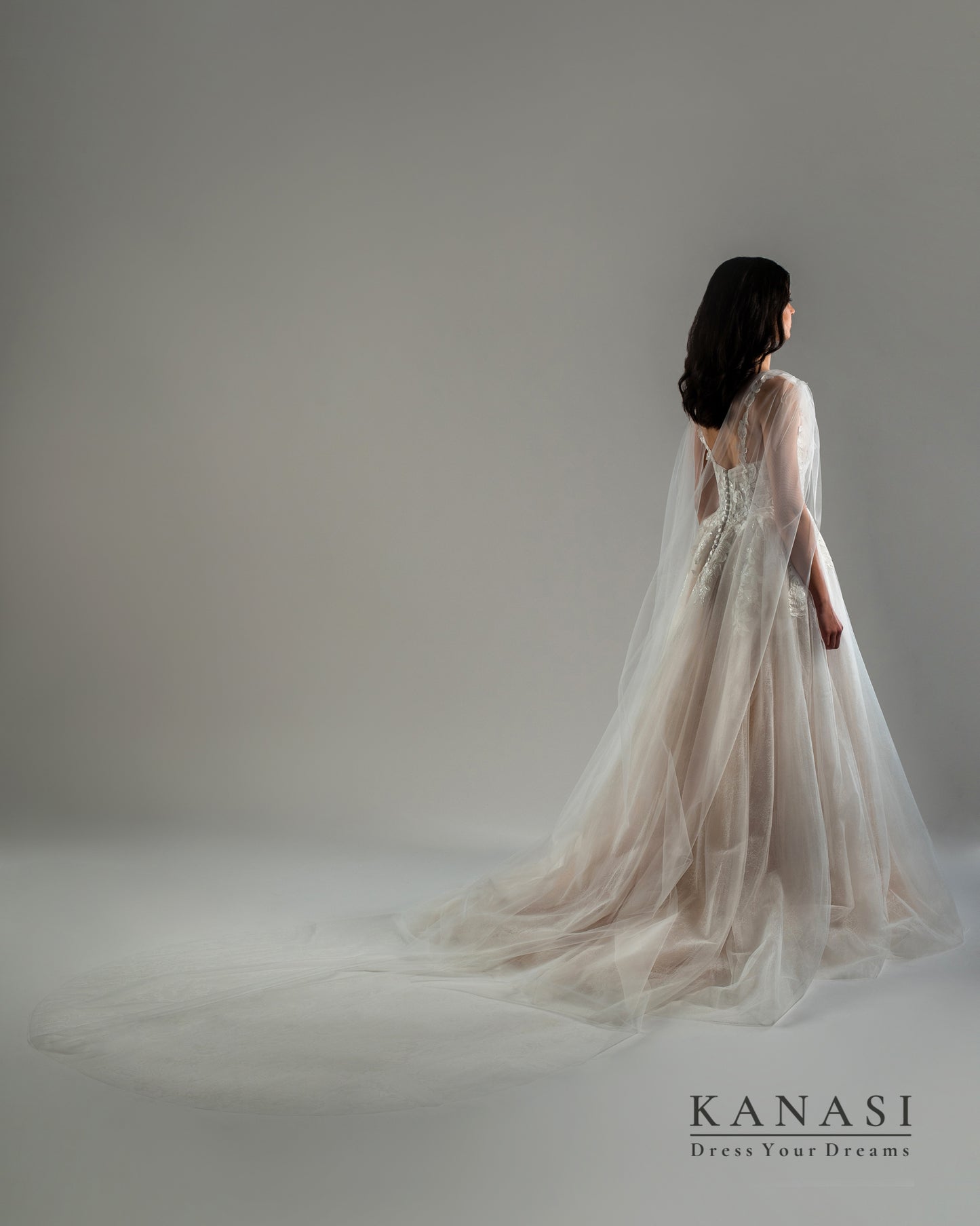 Fotografija čudovite poročne obleke z vlečko in tančico.