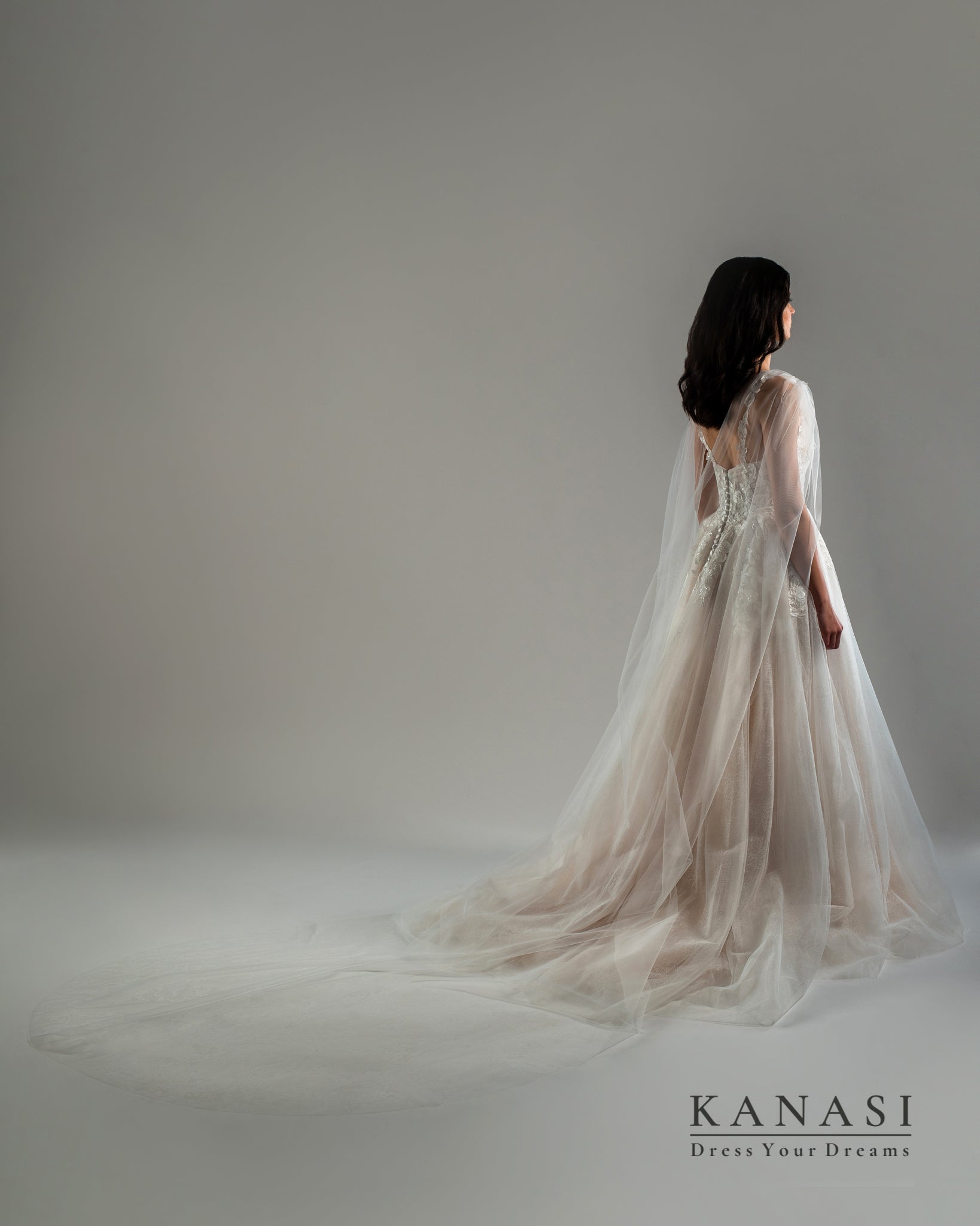 Fotografija čudovite poročne obleke z vlečko in tančico.