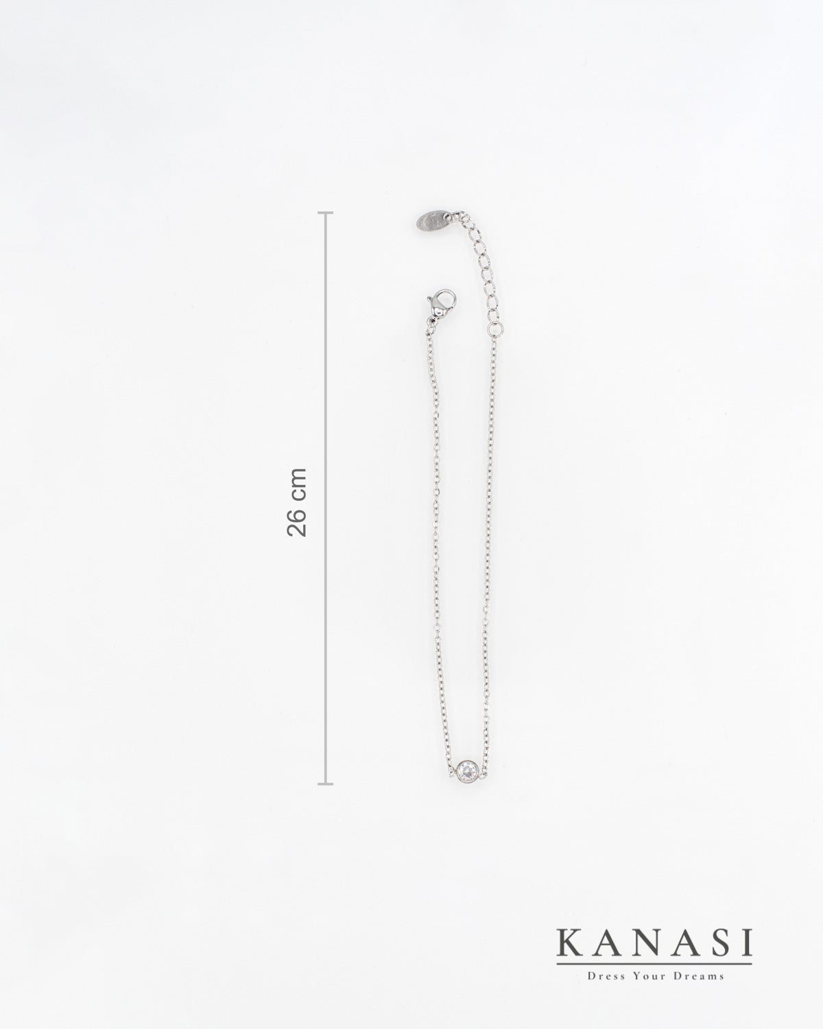 Srebrna verižica z okroglim kristalom in dolžino 26 cm – eleganten kos nakita Kanasi, prikazan z merilno oznako.